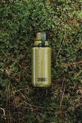 olive green modcan tactical water bottle with 'TacValve' logo on a grass surface