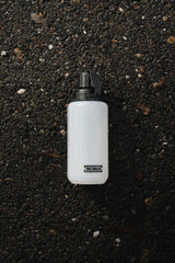 white modcan tactical water bottle with 'TacValve' logo on a black, textured surface