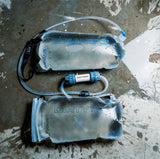 Two water filtration containers labeled 'Clean' and 'Dirty' on a concrete surface.