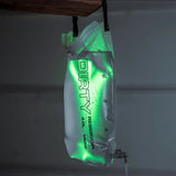 Clear water bladder with text labeled 'Dirty Reservoir' hanging against a neutral background with a green light reflecting