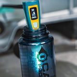 Blue water bottle with a steripen uv treatment device inside of it with a blurred background.