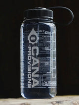 Clear Nalgene water bottle with black lid and 'cana provisions' branding on a dark background