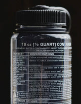 Close-up of a water treatment container label with text on a black background