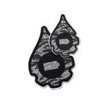 A pair of cana provisions geardrop logo shaped stickers featuring a grey striped camouflage pattern, shown on a plain white background.
