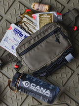 Fanny pack with medical equipment inside of it on a green surface