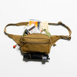 Tan waist bag with medical items on a white background