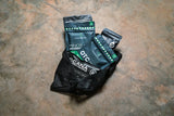 Mesh bag with OTC medication packages on a textured surface