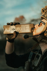 Person holding an iceflask tactical water bottle with a blurred natural background