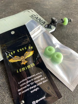 Green glow beads in a clear plastic bag with a Lumimod packaging on a dark surface.