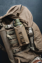 Brown backpack with a green water bottle on a dark background