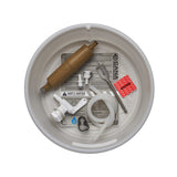 A top-down view of a white plastic bucket strainer containing white tubing, white spigot, spade bit, tubing clamp, MSR tan filter, quick disconnect fittings, red dirty tubing label and an instruction sheet on a white background.