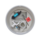 A top-down view of a white plastic bucket strainer containing white tubing, white spigot, spade bit, tubing clamp, sawyer filter, red dirty tubing label and an instruction sheet on a white background.