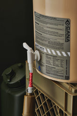 water filter components on a tan bucket with labels and hoses on a dark background