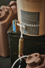 water filter components on a tan bucket with labels and hoses on a dark background