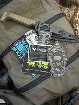 Collection of tactical stickers on a backpack with visible text and graphics.