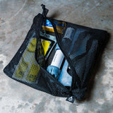 water filter gear in a black mesh pouch on a concrete surface.